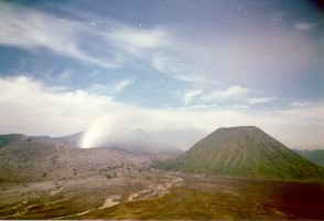 Dymiący krater wulkanu Bromo, obok majestatyczny stożek Gunung Batok